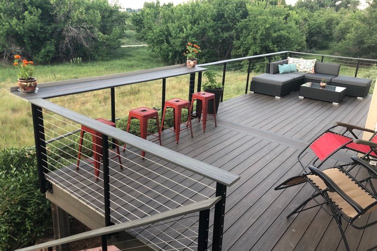 Custom cable railing handcrafted in Minneapolis by Paul Kraft MPLS Outdoor deck with black cable railings, bar stools, and sectional seating.